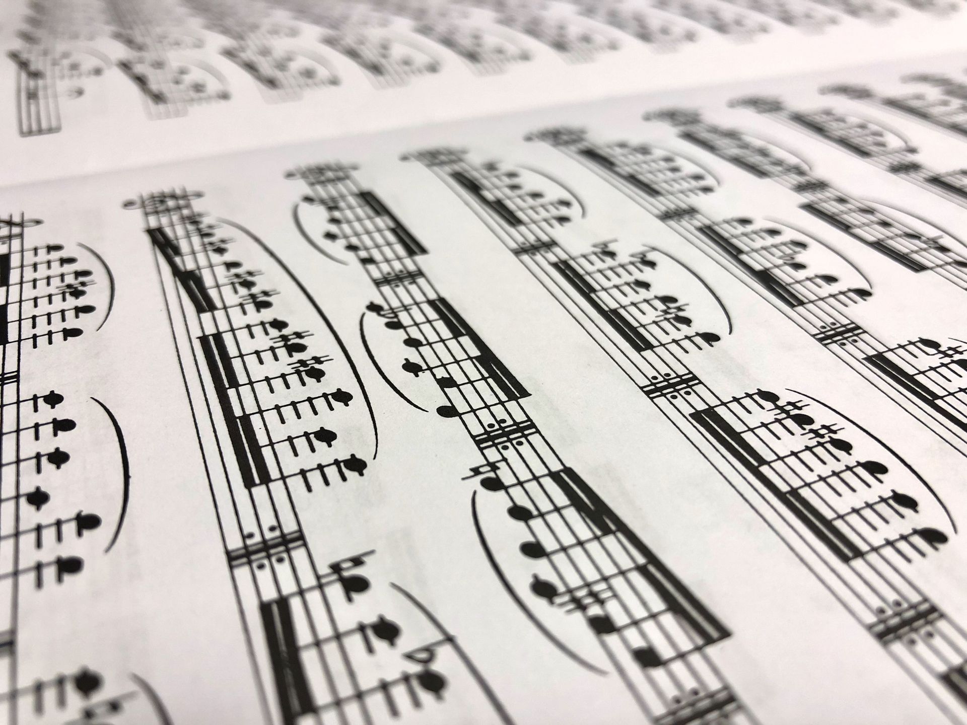 Detailed close-up shot of a musical sheet displaying notes in monochrome style.
